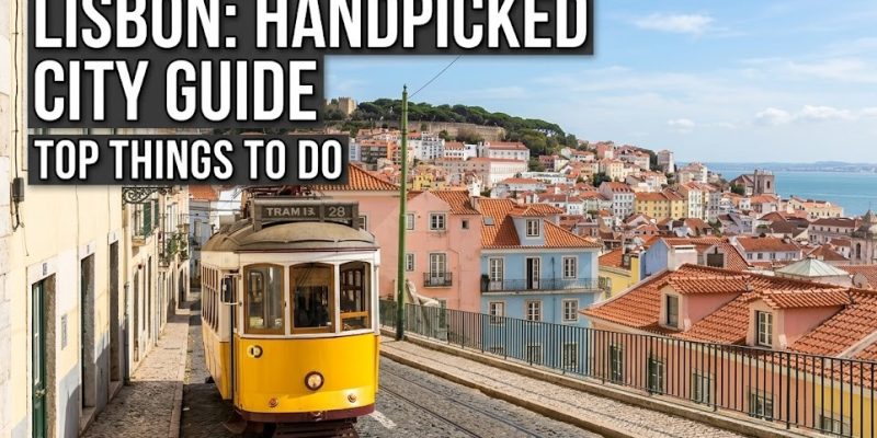 A scenic view looking down a steep, cobbled street in Lisbon featuring traditional colorful buildings and a historic yellow tram.