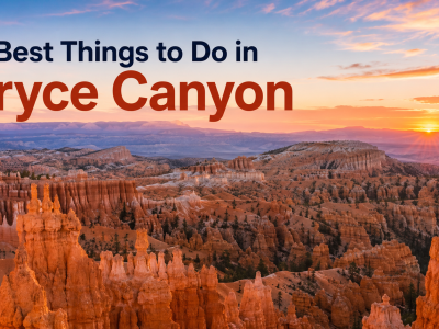 A panoramic high-angle shot of the Bryce Canyon Amphitheater filled with thousands of towering red, orange, and white limestone hoodoo rock formations under a clear sky.